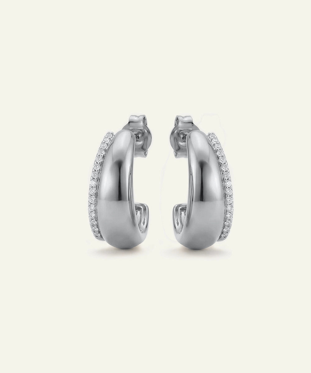 Pair of silver hoop earrings with embedded stones on a light gray background