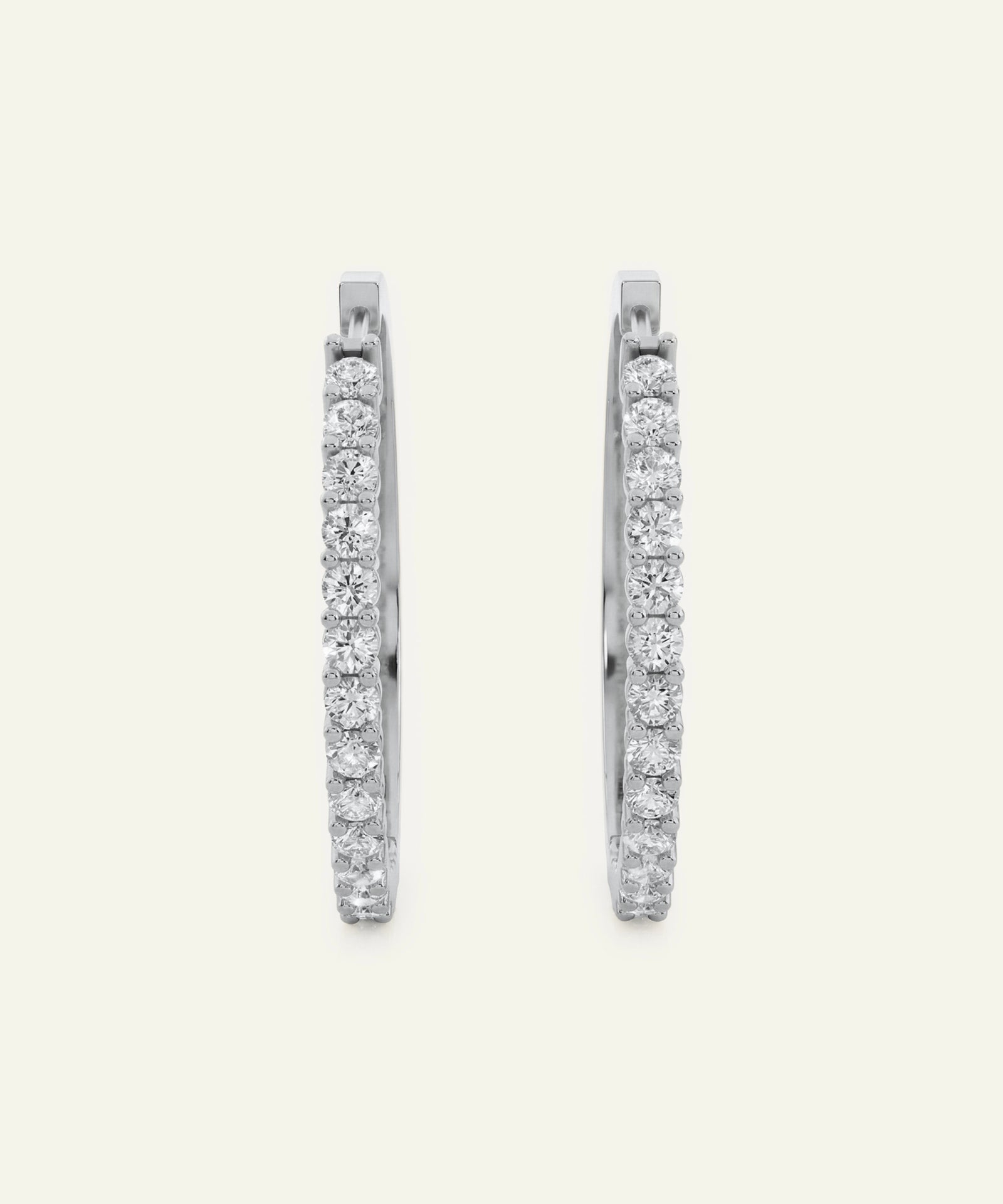 Pair of diamond hoop earrings on a light gray background