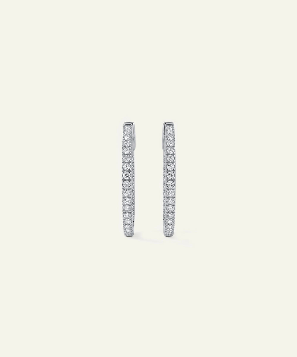Pair of diamond hoop earrings on a light gray background