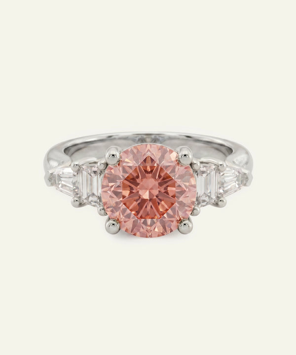 Ring with a pink diamond and silver setting on a white background