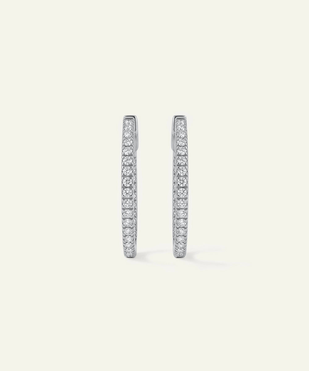 Pair of diamond hoop earrings on a light gray background