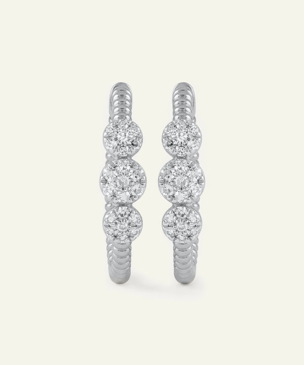Pair of diamond hoop earrings on a light gray background