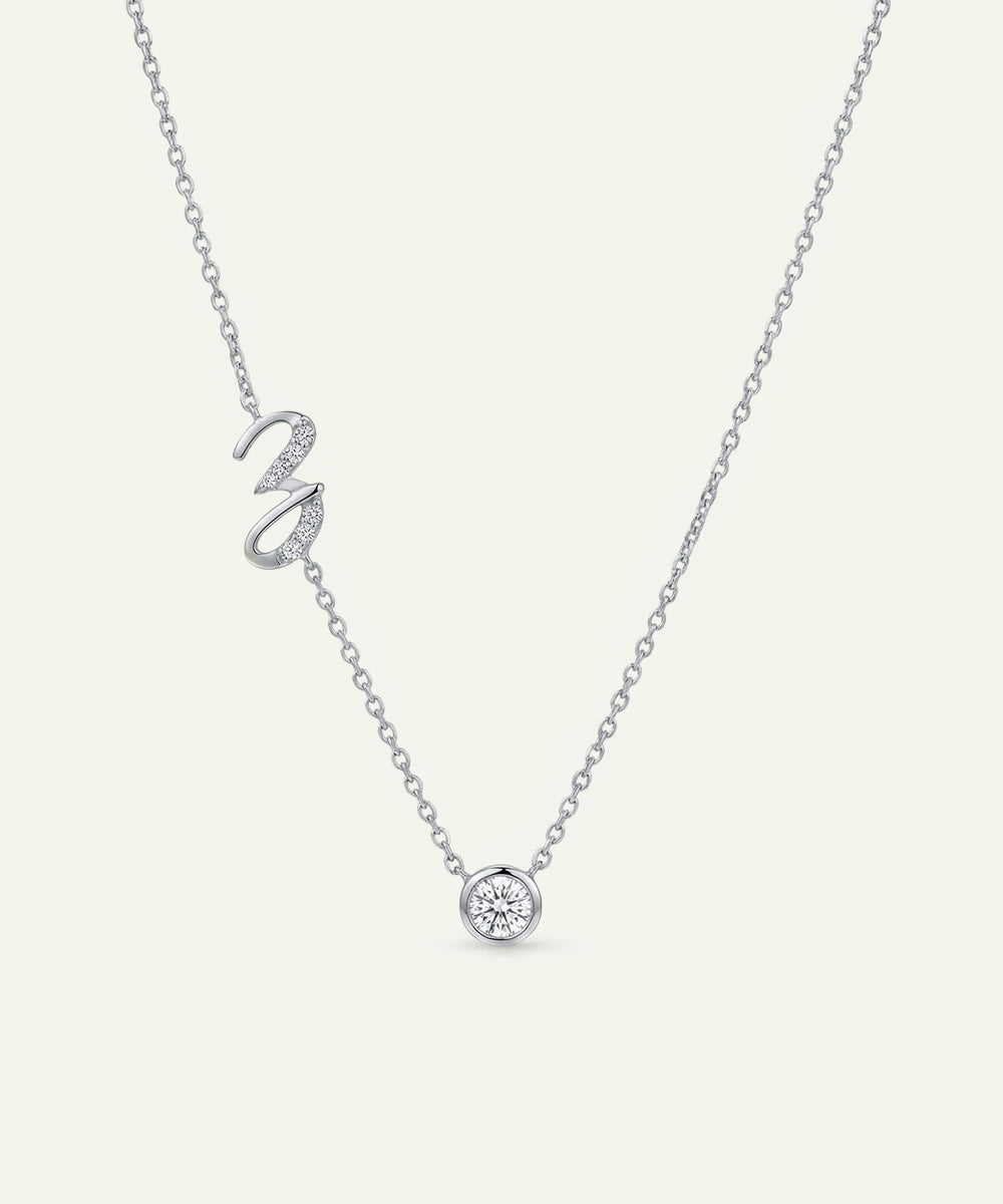 Silver necklace with a heart-shaped pendant on a light gray background