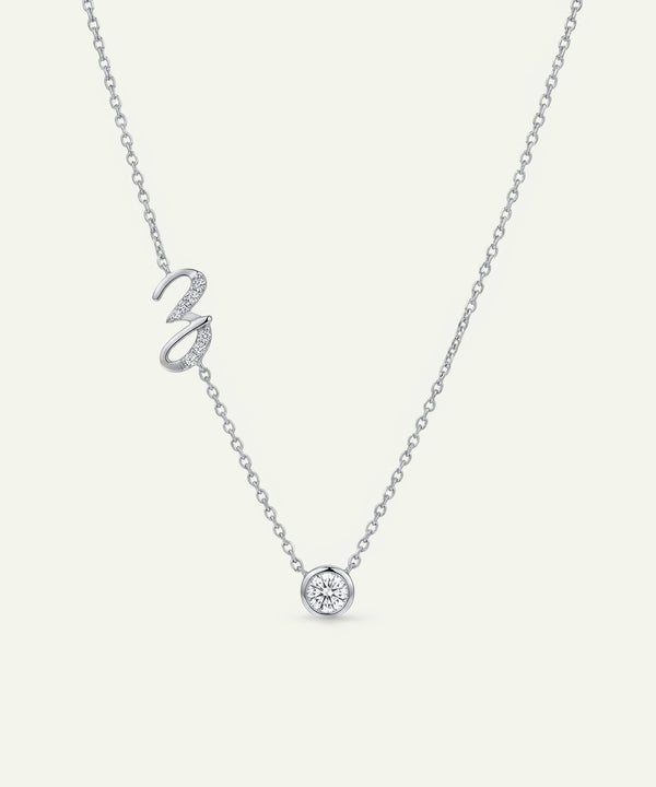 Silver necklace with a heart-shaped pendant on a light gray background