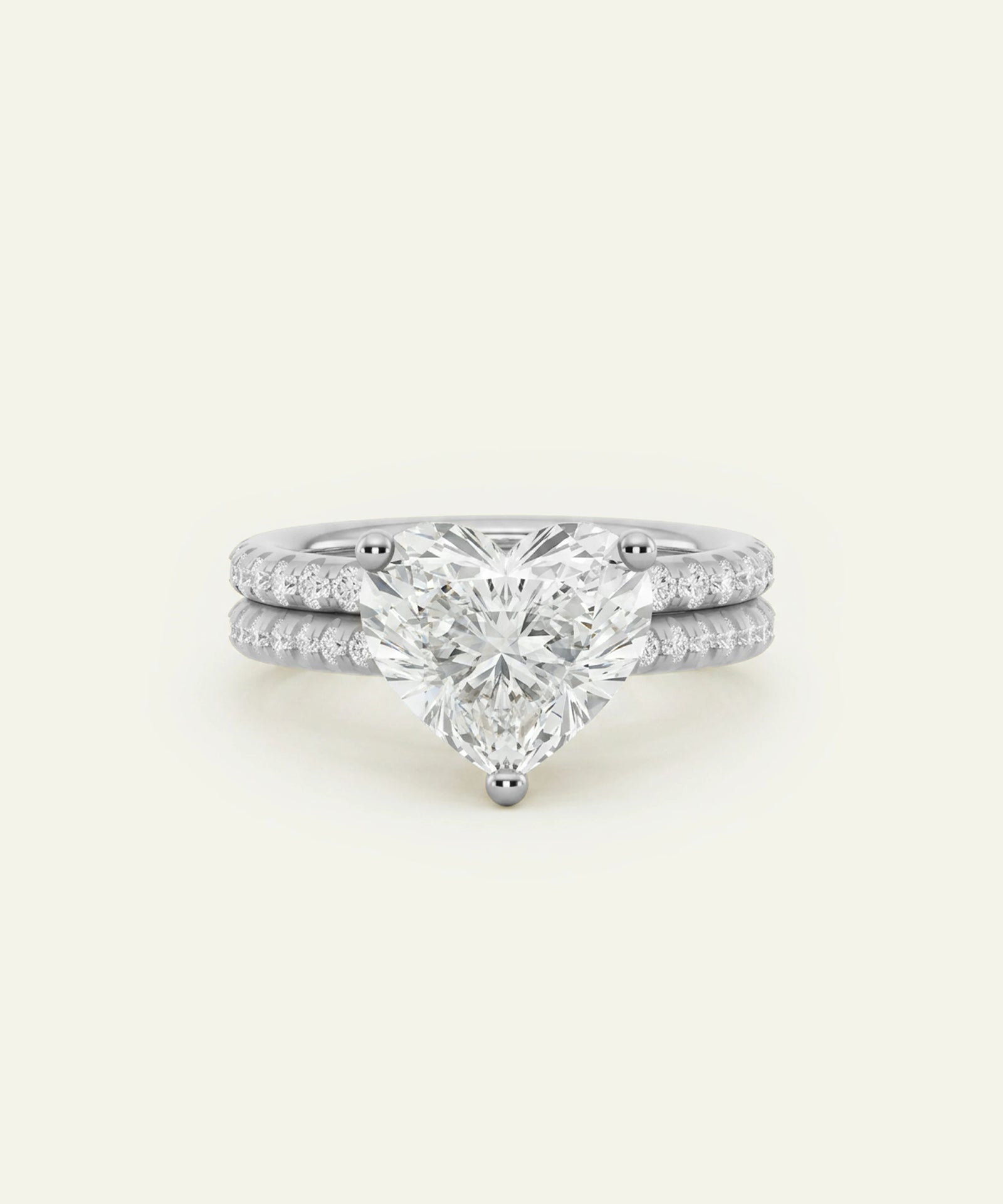 A white gold or platinum engagement ring set with a large pear-cut center stone and a matching pave diamond band, shown on a clean off-white background.