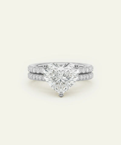 A white gold or platinum engagement ring set with a large pear-cut center stone and a matching pave diamond band, shown on a clean off-white background. - alternate view