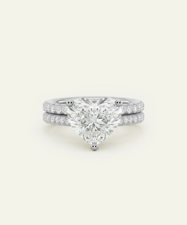 A white gold or platinum engagement ring set with a large pear-cut center stone and a matching pave diamond band, shown on a clean off-white background.