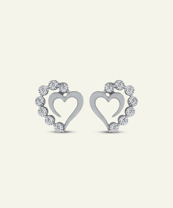 Pair of silver heart-shaped earrings with diamond accents on a light gray background
