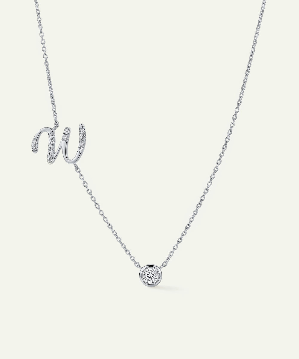 Silver necklace with a 'W' pendant on a light gray background