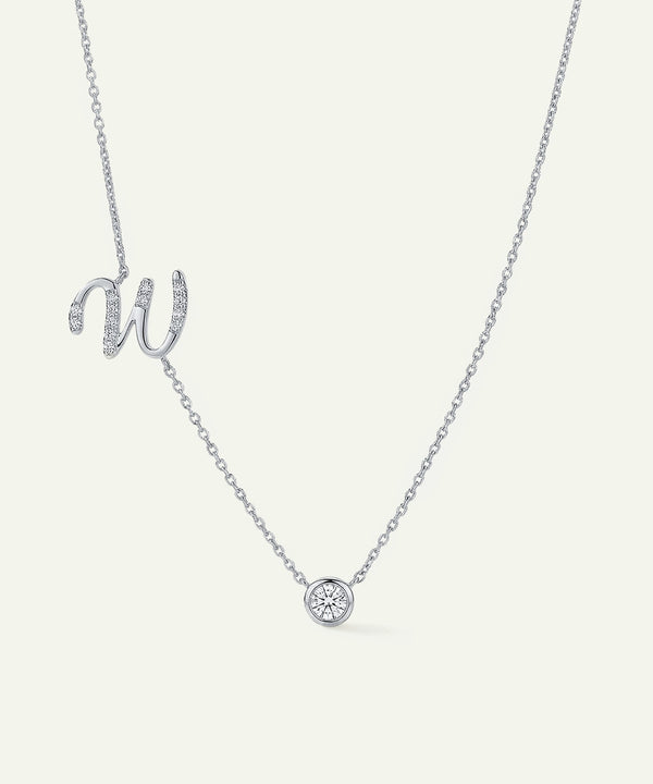Silver necklace with a 'W' pendant on a light gray background