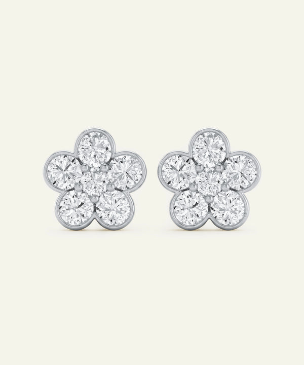 Pair of silver flower-shaped earrings with clear gemstones on a white background