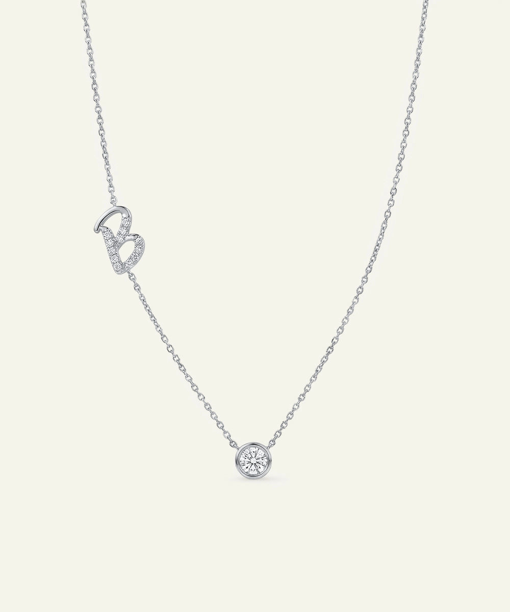 Silver necklace with a small round pendant on a light gray background