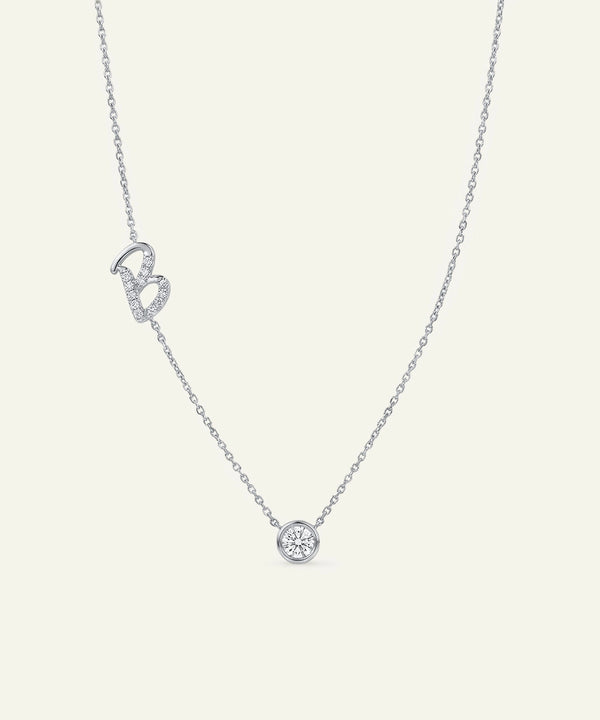 Silver necklace with a small round pendant on a light gray background