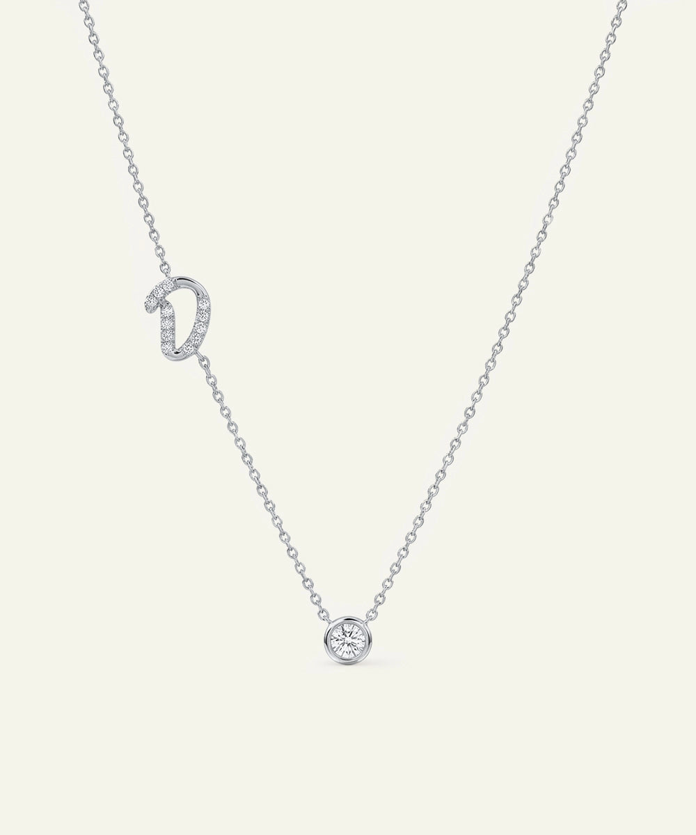 Silver necklace with a small round pendant on a light gray background