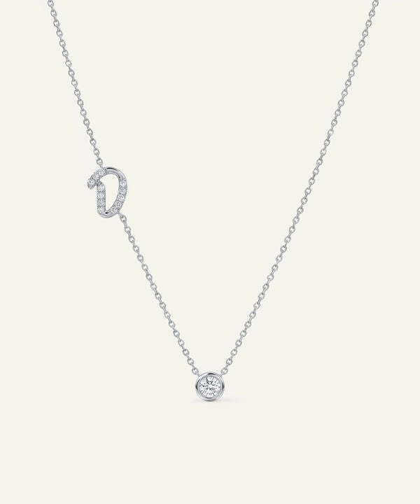 Silver necklace with a small round pendant on a light gray background