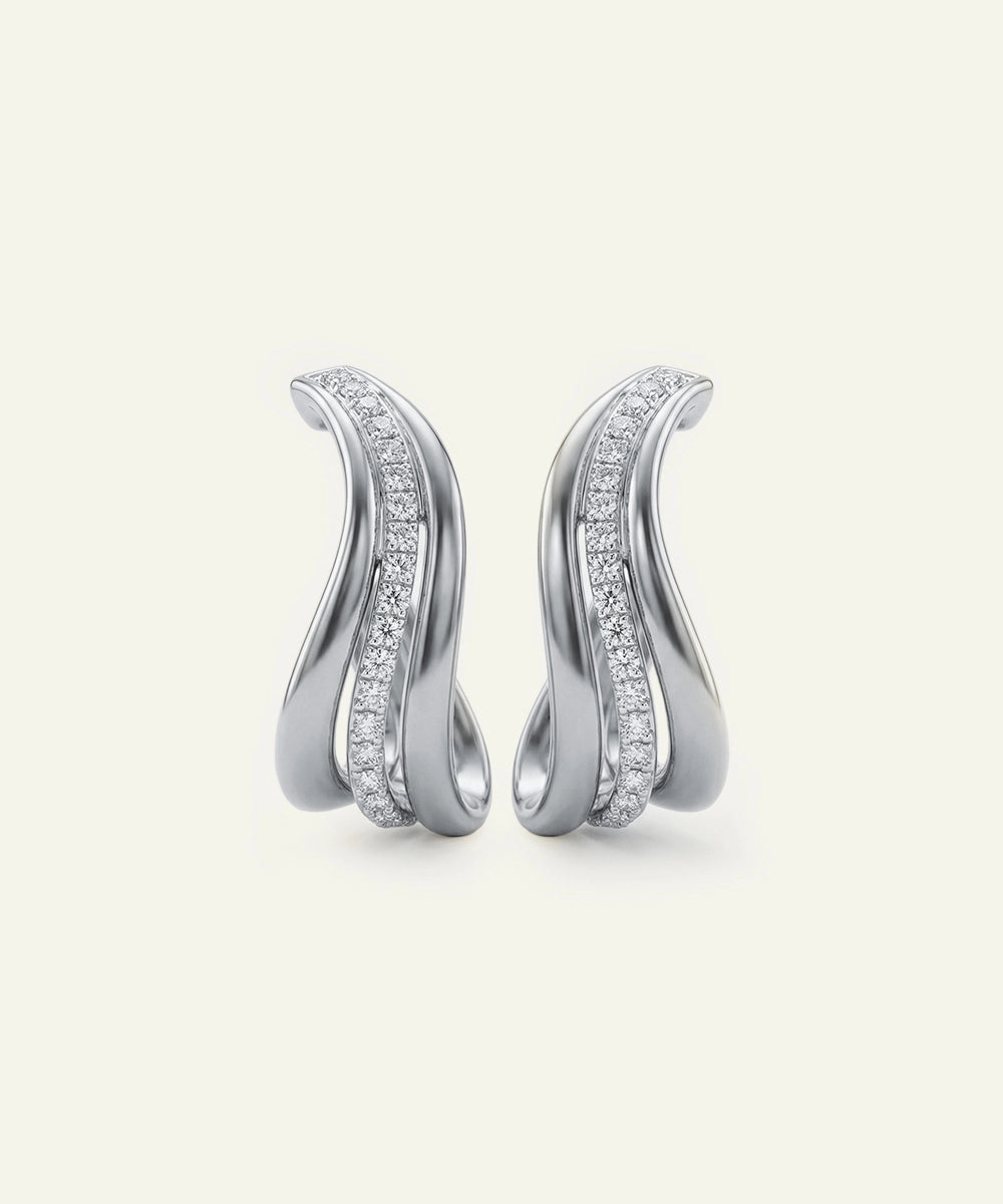 Pair of silver earrings with diamond accents on a light gray background