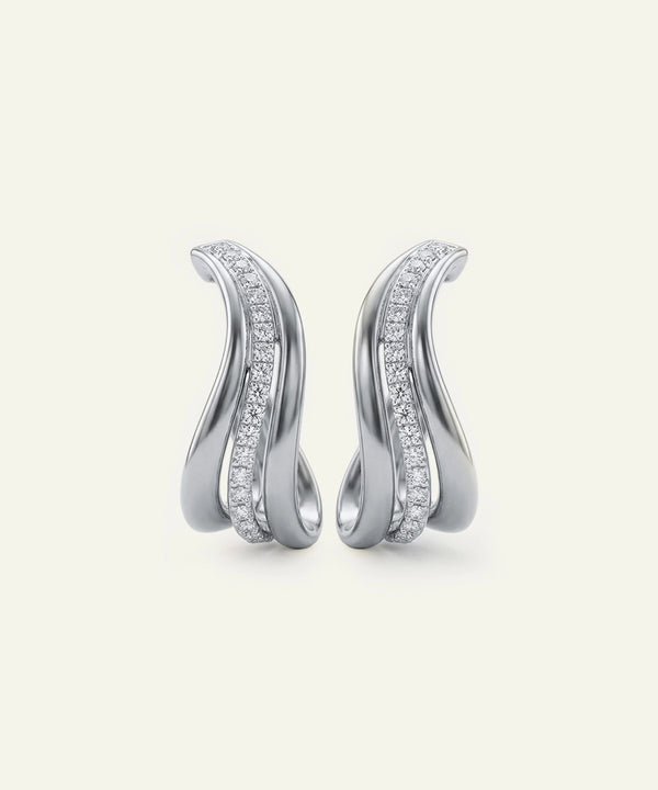 Pair of silver earrings with diamond accents on a light gray background