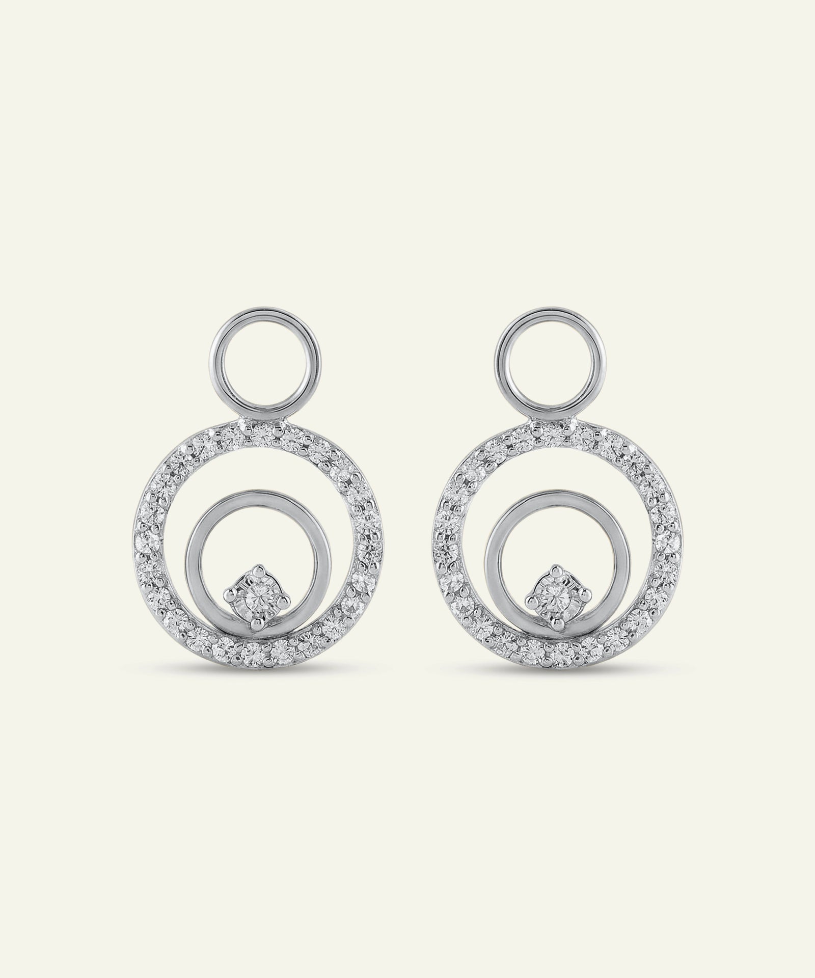 Pair of silver earrings with circular design on a light gray background