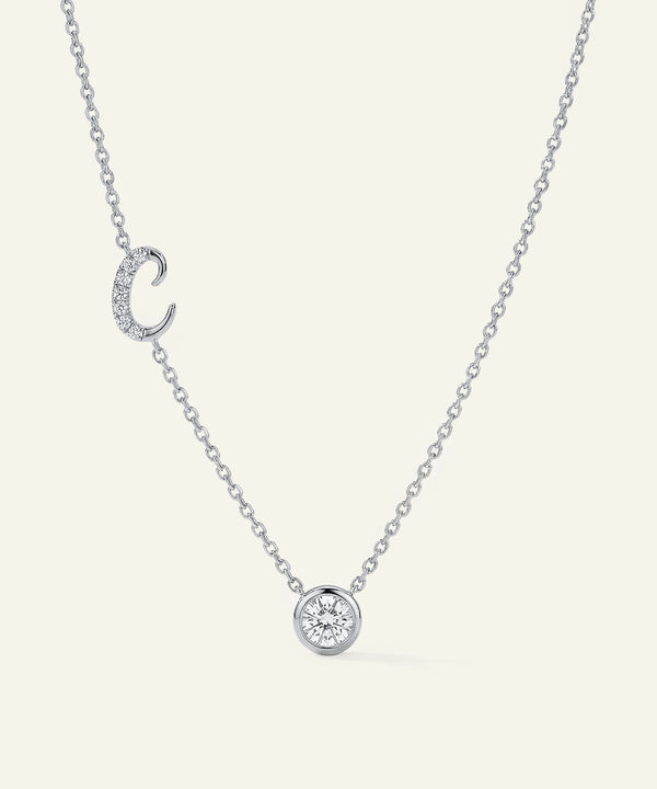 Silver necklace with a small round pendant on a white background