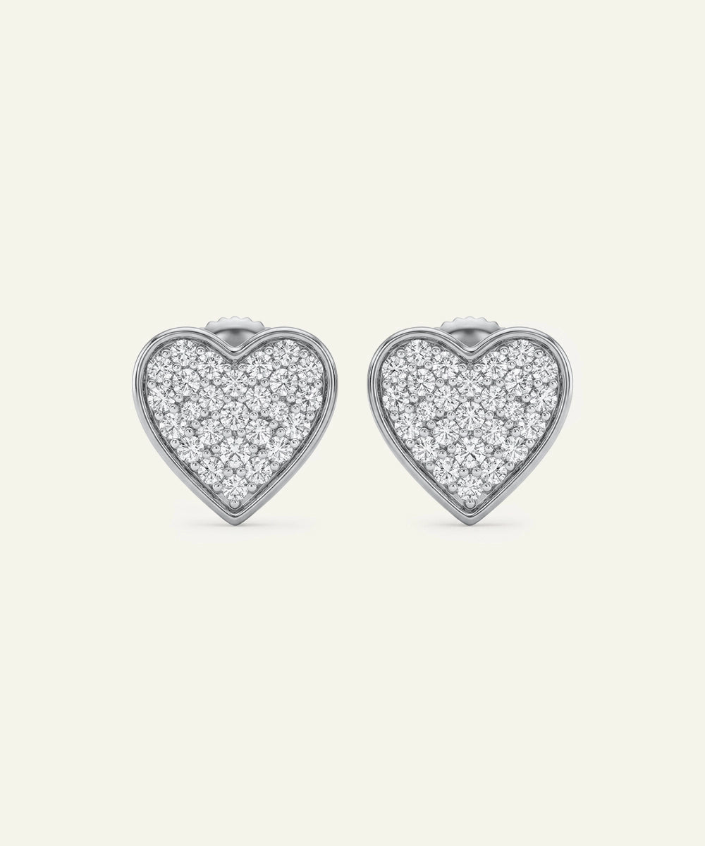Heart-shaped earrings with diamond pavé on a white background
