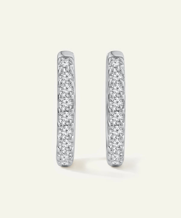 Pair of diamond hoop earrings on a light gray background