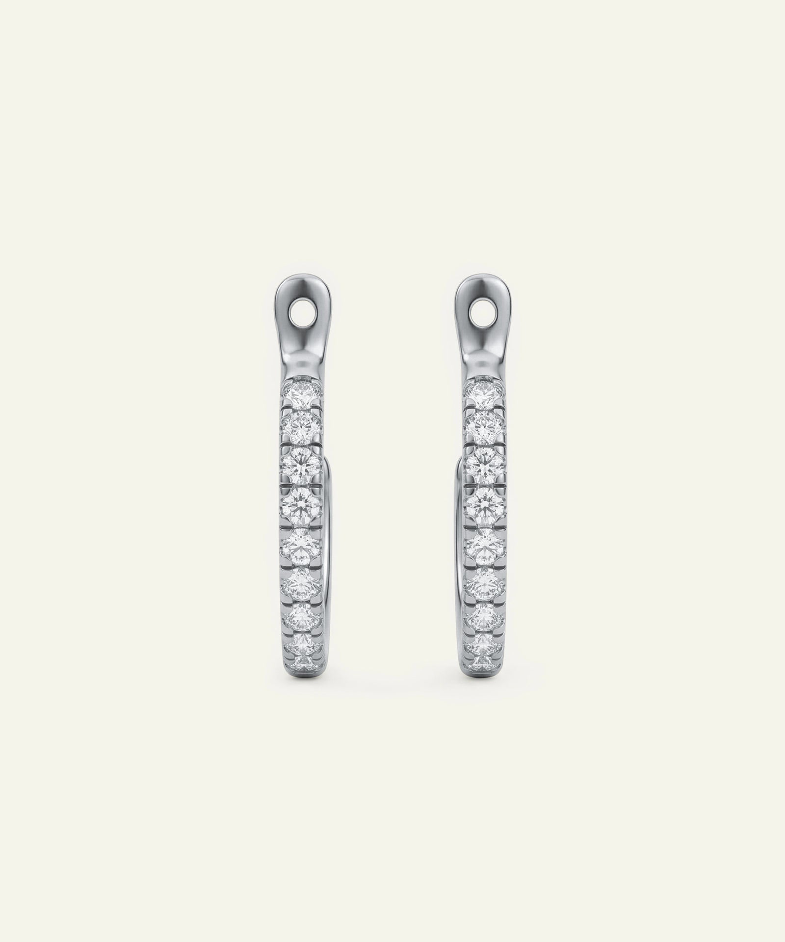 Pair of silver earrings with clear gemstones on a white background