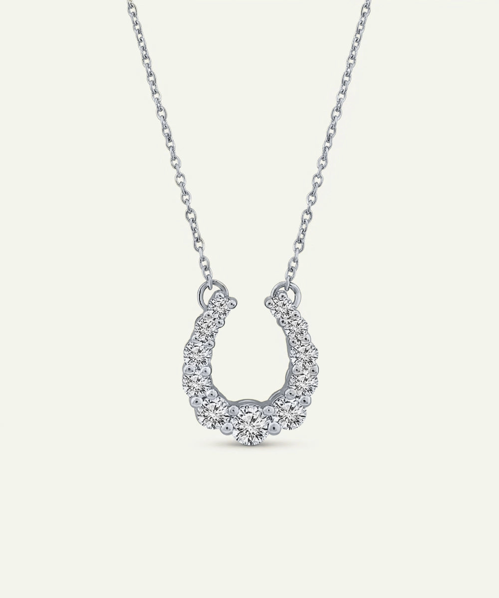 Silver horseshoe pendant necklace on a white background