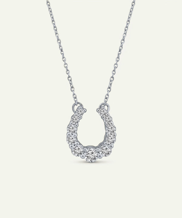 Silver horseshoe pendant necklace on a white background