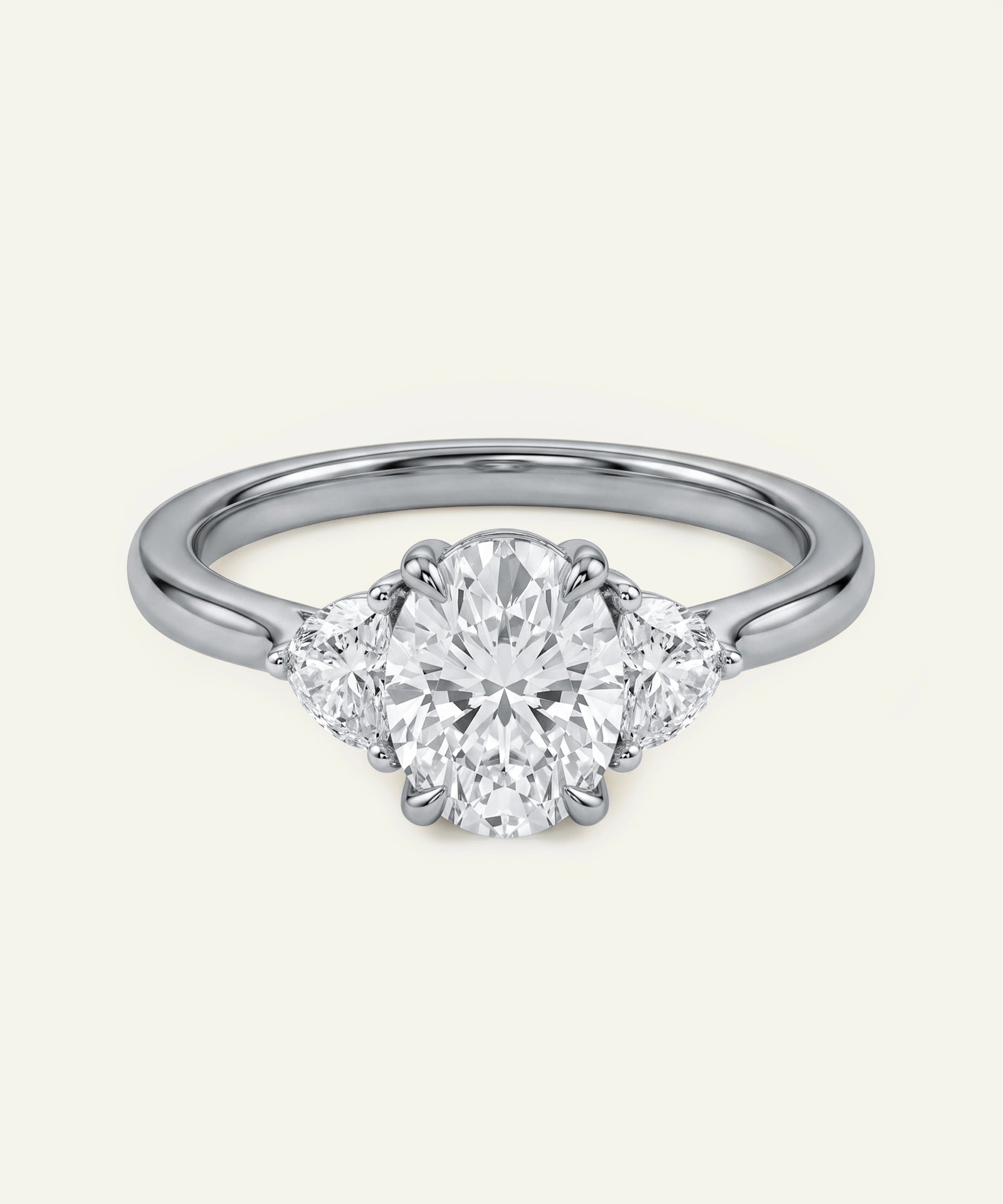 Oval diamond three-stone engagement ring with half-moon accent diamonds.