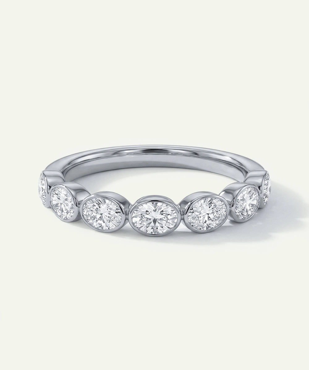 Silver ring with round diamonds on a light gray background