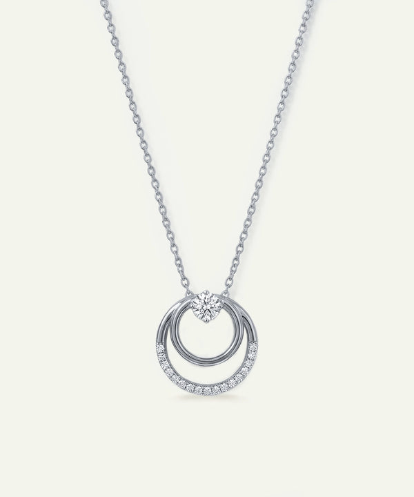 Silver necklace with a circular pendant on a light gray background