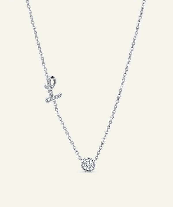 Silver necklace with a small round pendant on a light gray background