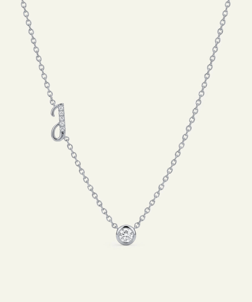 Silver necklace with a small round pendant on a light gray background