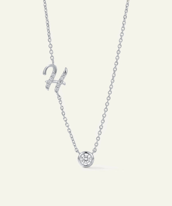Silver necklace with a small round pendant on a white background
