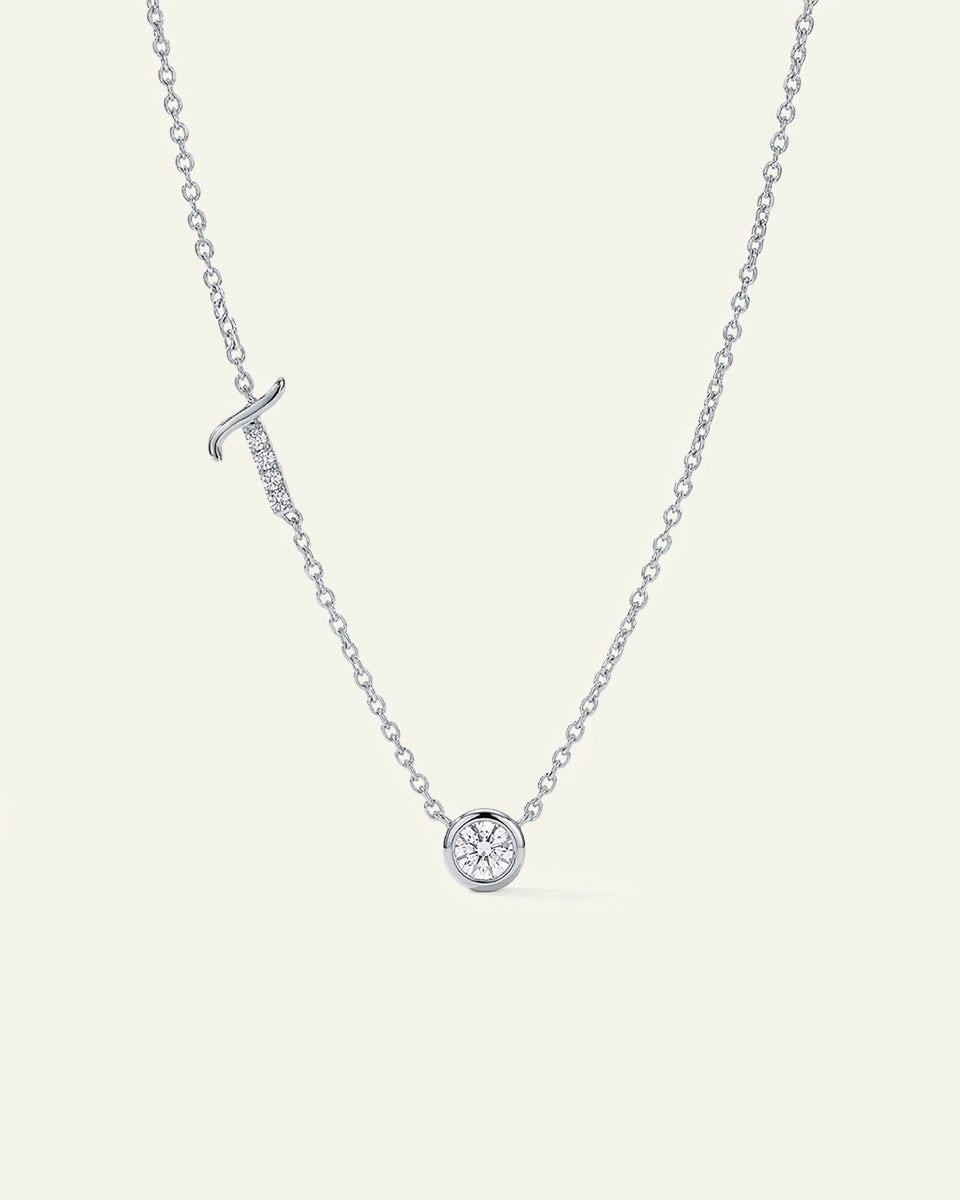 Silver necklace with a small round pendant on a light gray background