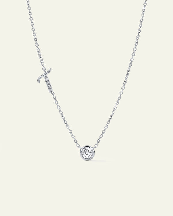Silver necklace with a small round pendant on a light gray background