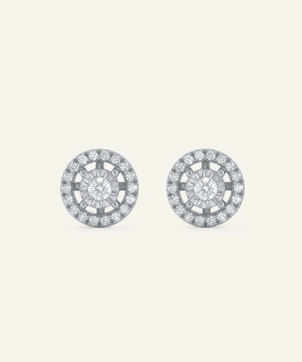 Pair of round earrings with diamond-like stones on a light gray background