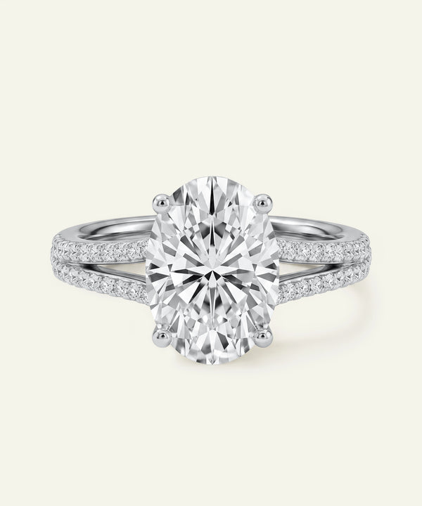 Oval-cut diamond engagement ring with a pavé split-shank band.