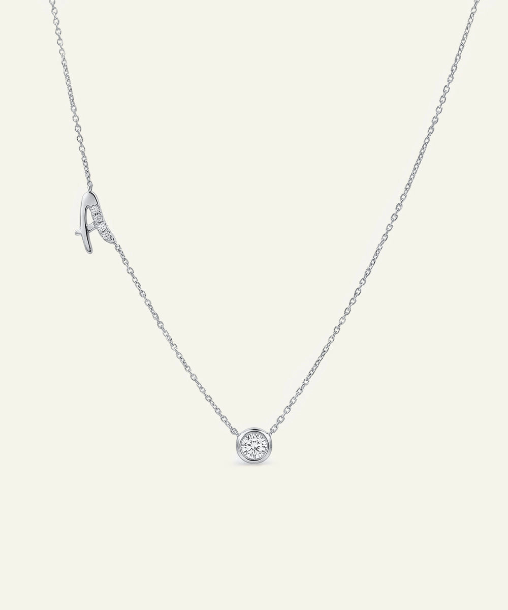 Silver necklace with a round pendant on a light gray background