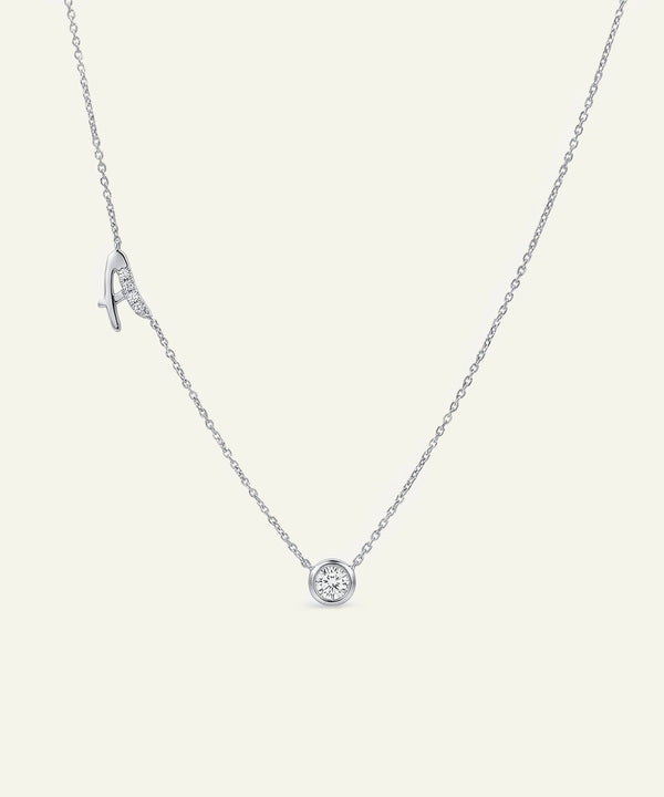 Silver necklace with a round pendant on a light gray background