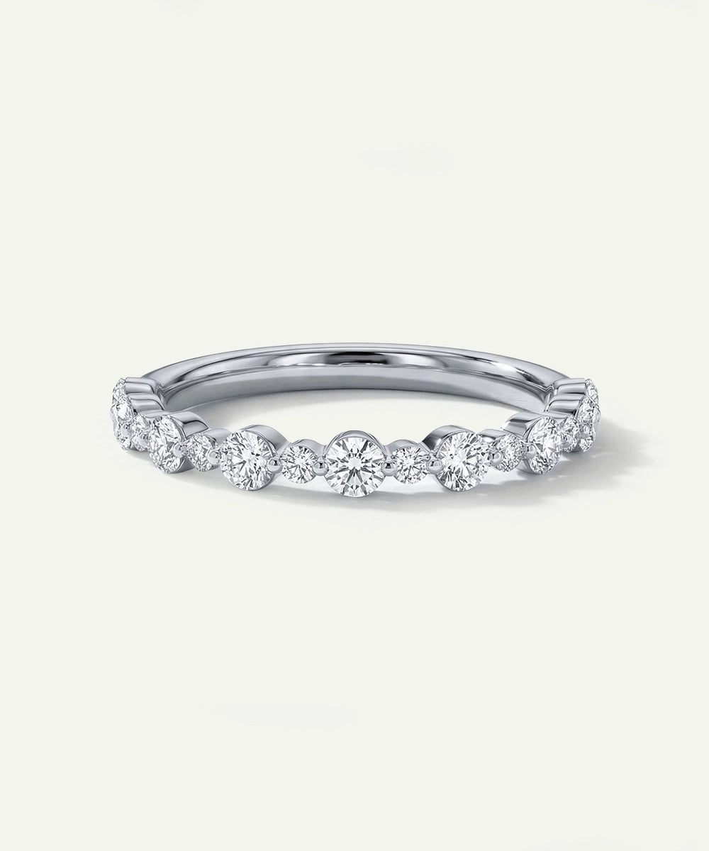 Silver ring with small diamonds on a light gray background