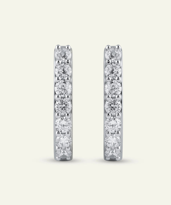 Pair of diamond hoop earrings on a light gray background