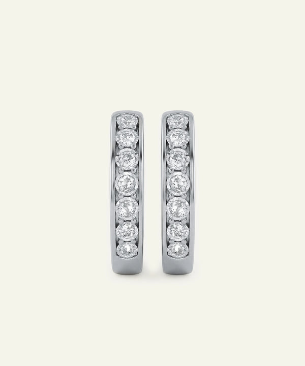 Pair of diamond hoop earrings on a light gray background