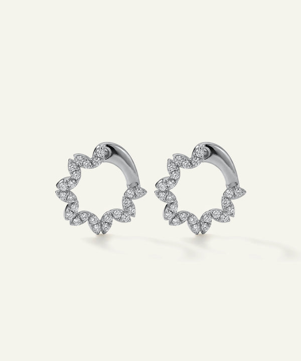 Pair of silver hoop earrings with diamond accents on a light gray background