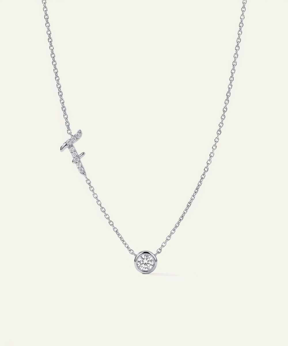 Silver necklace with a round pendant on a light gray background