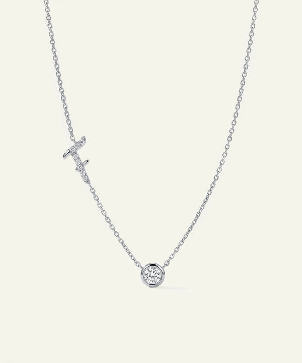 Silver necklace with a round pendant on a light gray background