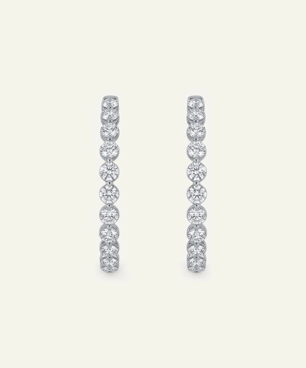 Pair of diamond hoop earrings on a light gray background