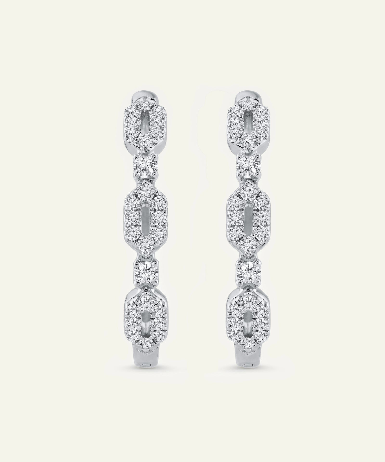 Pair of diamond earrings on a light beige background