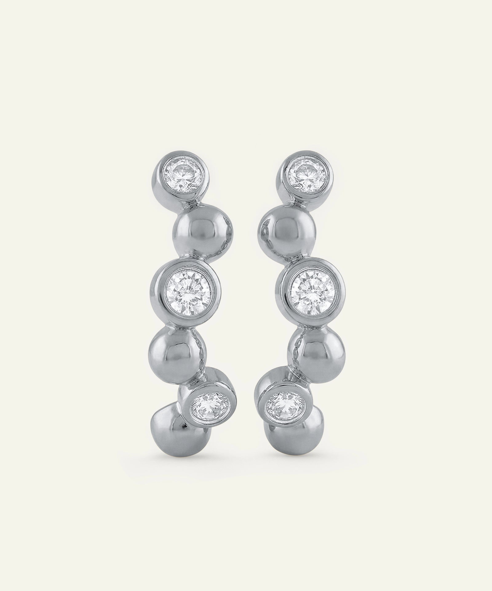 Silver earrings with clear gemstones on a white background