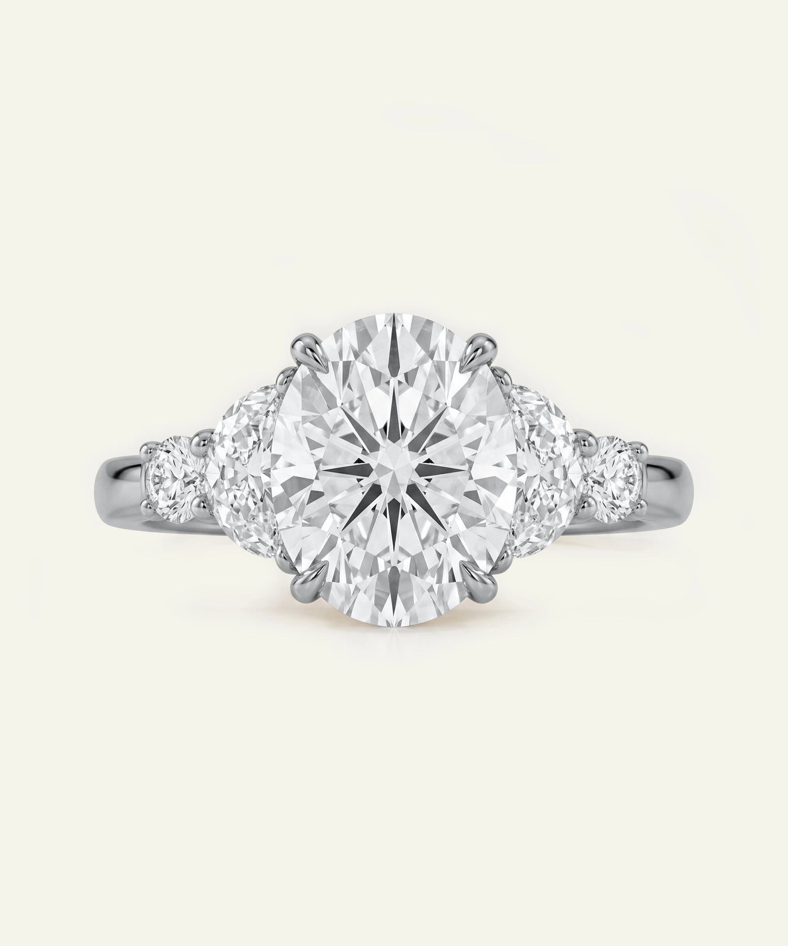 Oval diamond five-stone engagement ring with half-moon side diamonds on a platinum or white gold band.